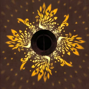 close‑up view of delicate peacock pattern projection from bronze solar lantern.